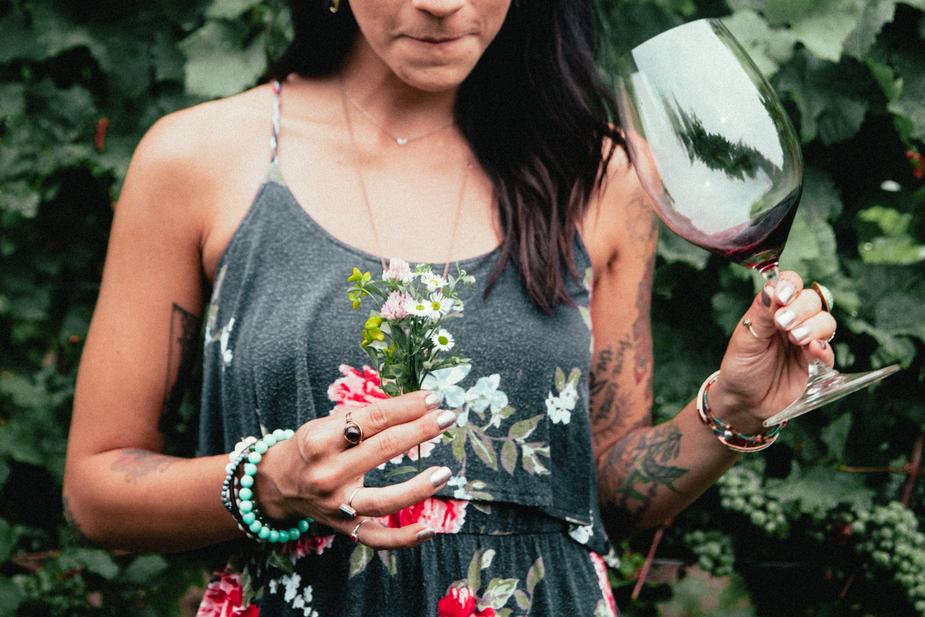 Womens fashion tattooed woman holding flowers and wine.jpg